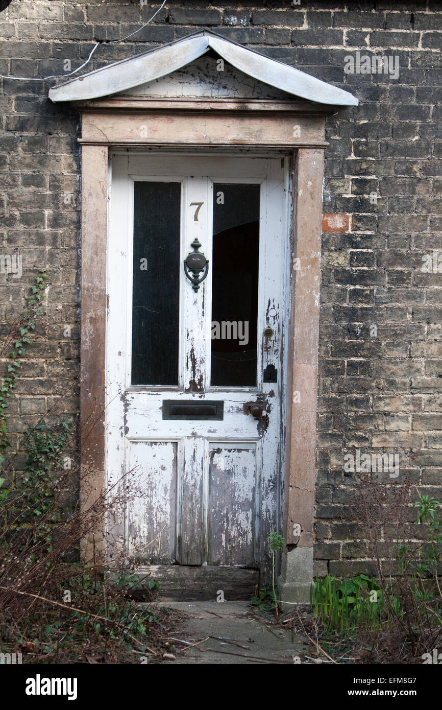 The white front door of a derelict cottage on Orchard Street, Cambridge, UK Stock Photo