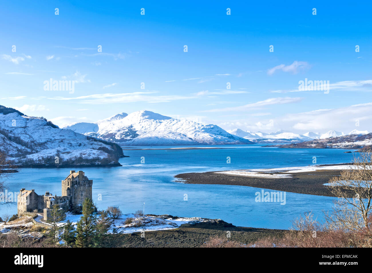 EILEAN DONAN CASTLE AND LOCH DUICH WITH A HEAVY FALL OF SNOW ON THE CUILLIN MOUNTAINS Stock Photo