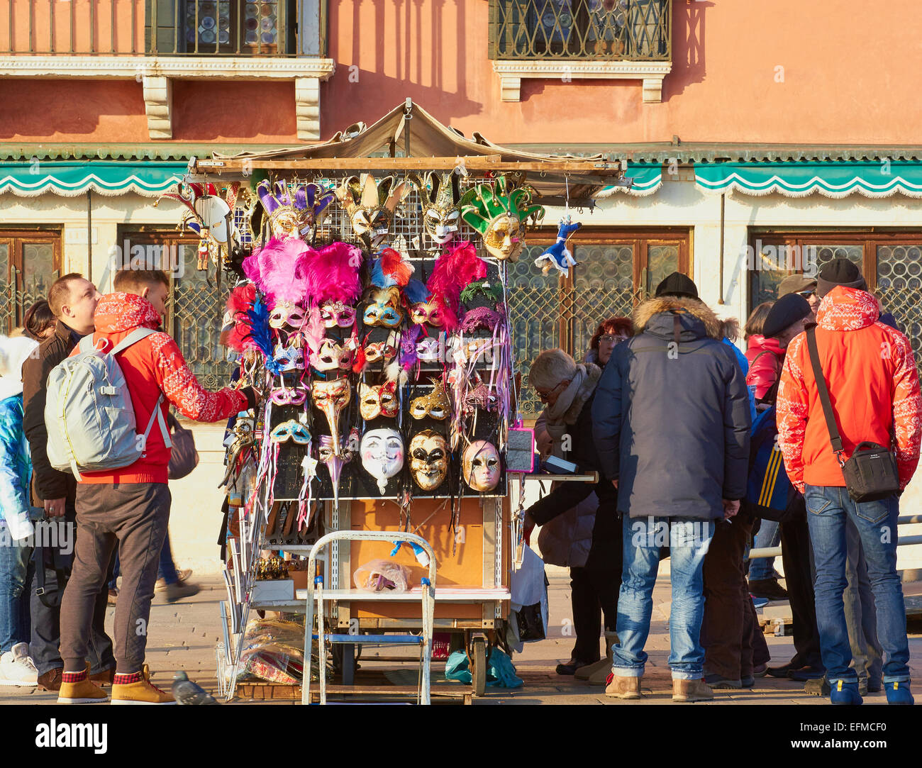 Tourists looking at traditional decorative masks on a stall Venice Veneto Italy Europe Stock Photo