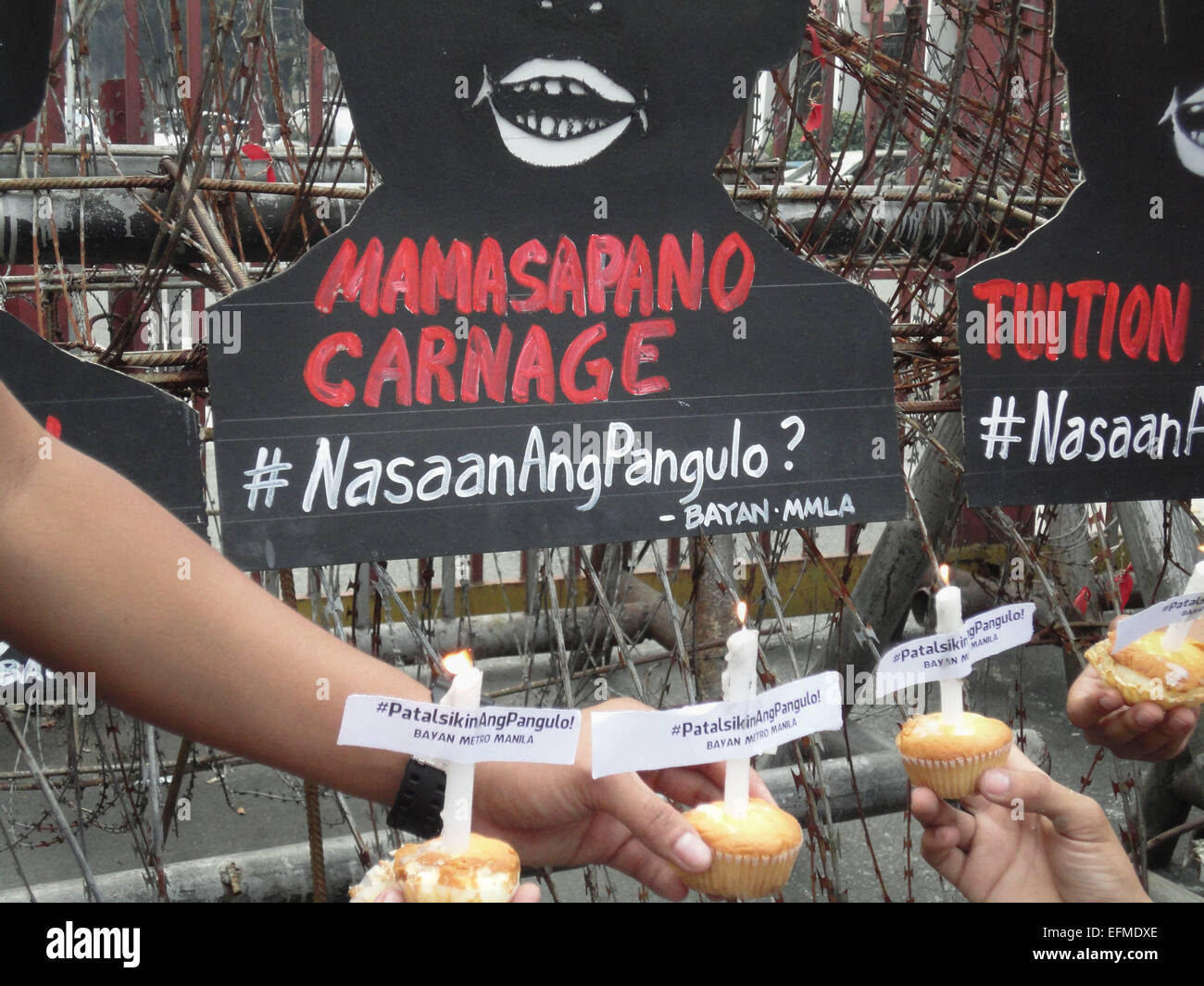Filipino protesters hold cupcakes with candles in front of shadow cut-outs of President Benigno Aquino III near Malacanang presidential palace, a day before President Aquino's 55th birthday. Each cut-out contains topics that hound the nation, one of which is the recent Mamasapano clash, where suspected Malaysian bombmaker Zulkifri 'Marwan' Abdhir was reportedly killed. The hashtag '#NasaanAngPangulo' reads in English as, 'Where is the President?' © Richard James Mendoza/Pacific Press/Alamy Live News Stock Photo