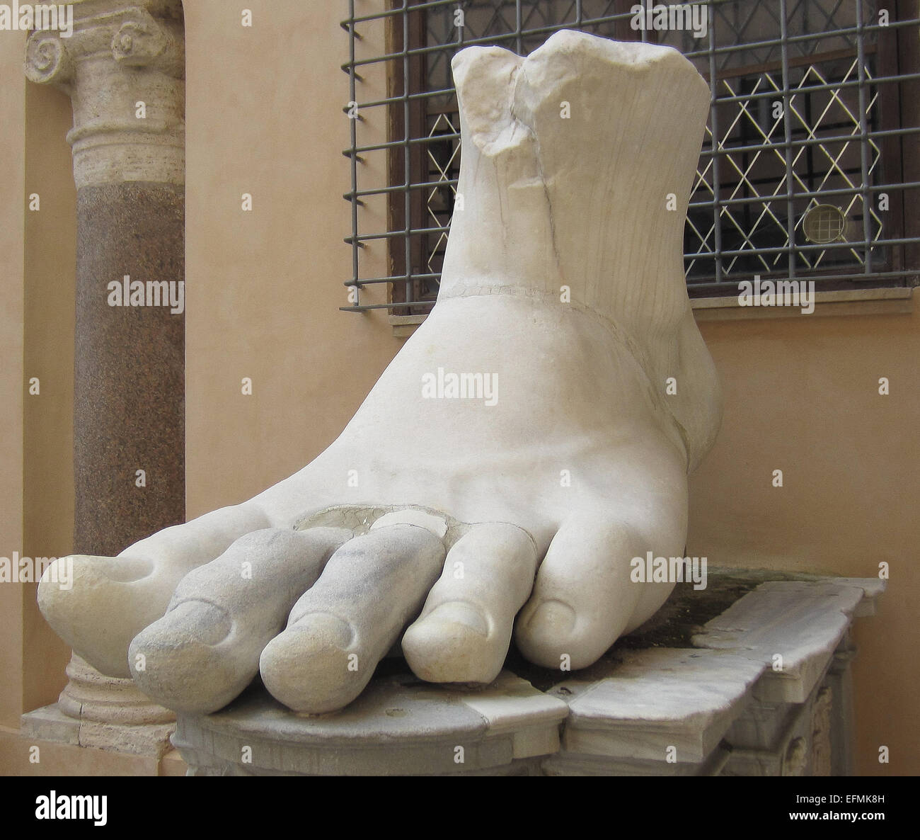 This huge foot was part of the Colossus of Constantine, a huge statue of the Roman Emperor Constantine that once stood in the Basilica of Maxentius, near the Roman Forum in Rome. The foot is carved from marble. The statue dates to after Constantine's great victory over Maxentius at the Battle of Milvian Bridge in A.D. 312. In Late Antiquity, the statue was pillaged for its parts. This foot, hands, and head are now housed in the Capitoline Museum in Rome. The photo dates to March 2014. Stock Photo