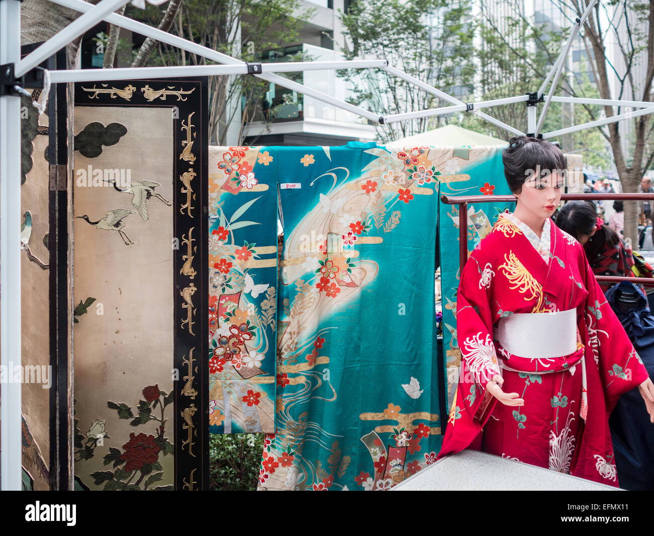 Woman dressed in colorful Geisha kimono costume shopping in the Marunouchi weekend flea market Stock Photo