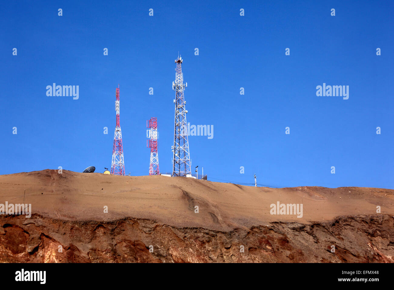 Mobile phone / radio masts on desert hillside near the El Morro headland, near Arica, Chile Stock Photo