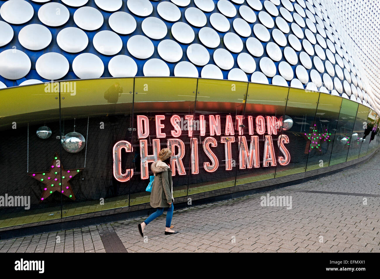 Christmas shoppers Birmingham Selfridges walk past destination christmas neon sign Stock Photo