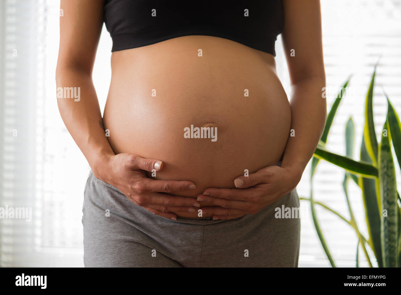 Baby bump, Image of 8 month pregnant woman holding her bump Stock Photo