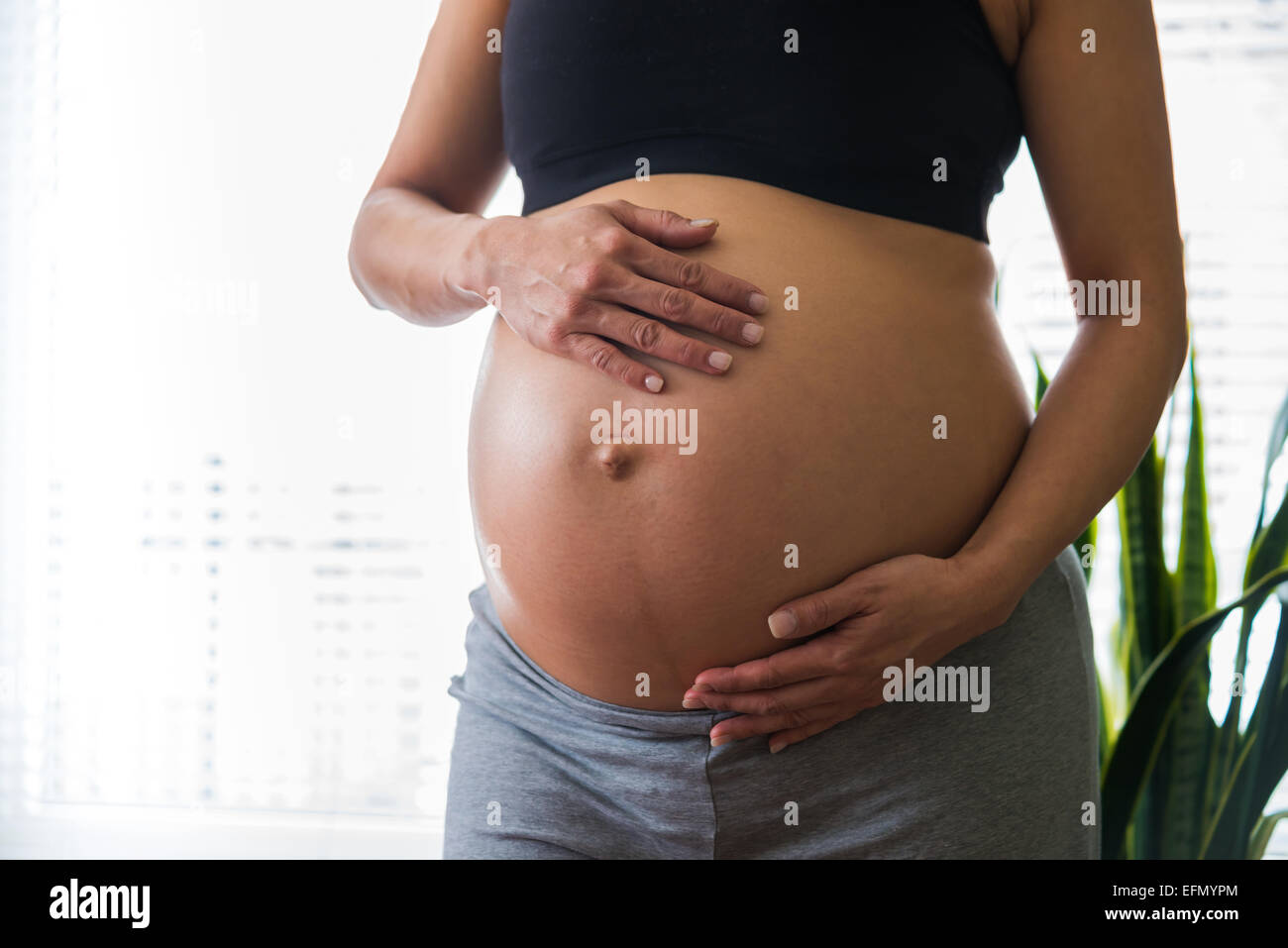 Baby bump, Image of 8 month pregnant woman holding her bump Stock Photo