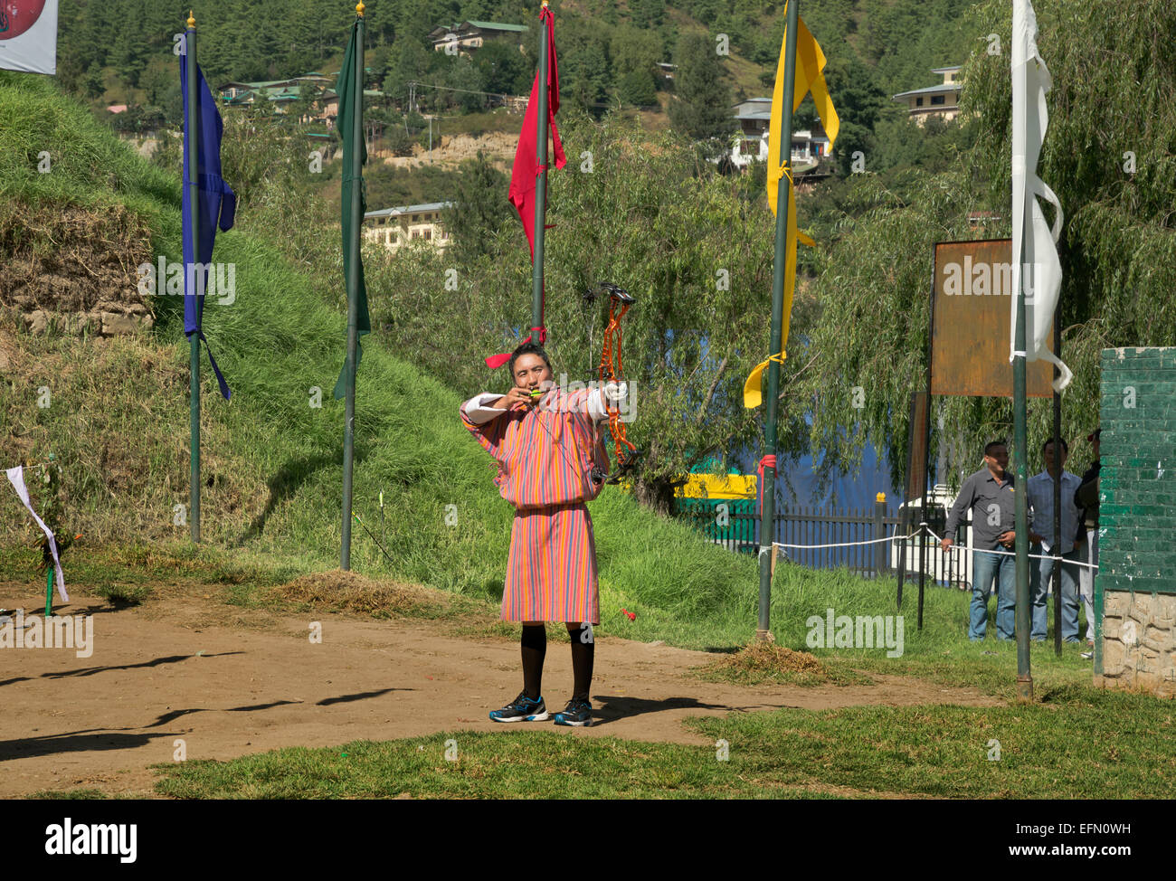 BU00057-00...BHUTAN - Archer in traditional garb (a gho) taking part in a tournament shooting at a target 145 meters away. Stock Photo