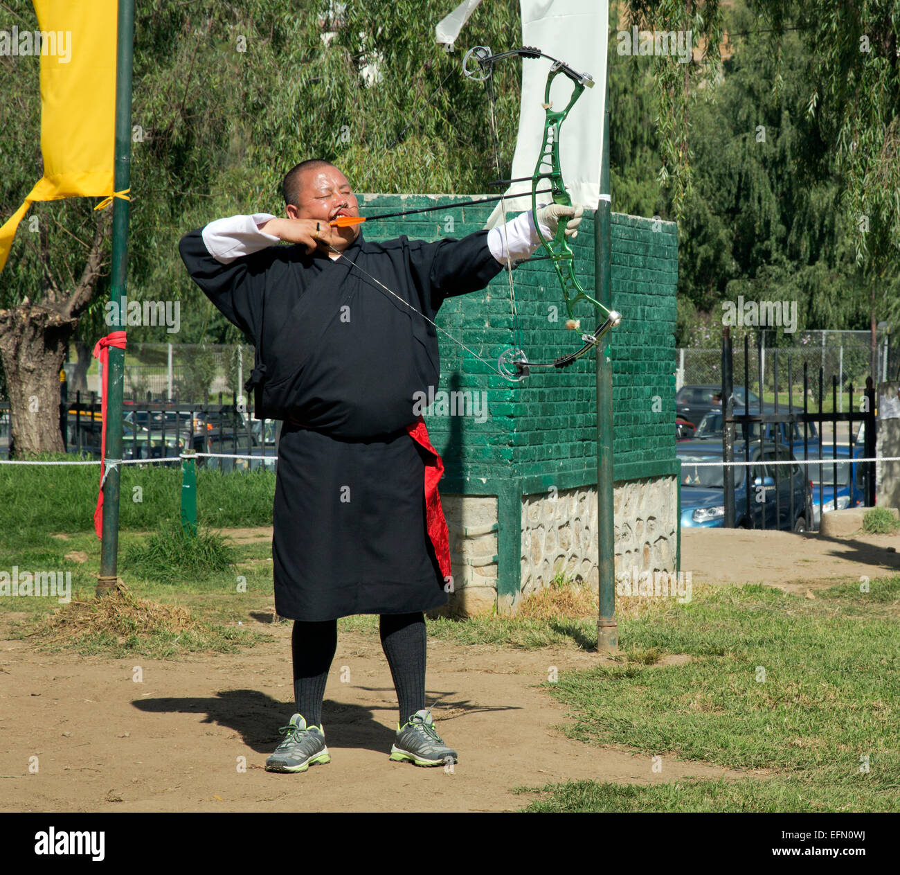 BU00058-00...BHUTAN - Archer in traditional garb (a gho) taking part in a tournament, shooting at a target 145 meters away. Stock Photo