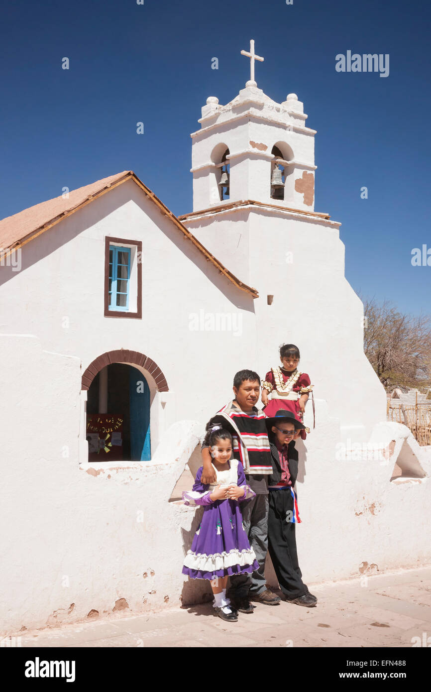 Local family dressed up for Sept 18 Independence Day holiday and posing for photos near adobe San Pedro church, San Pedro, Chile Stock Photo