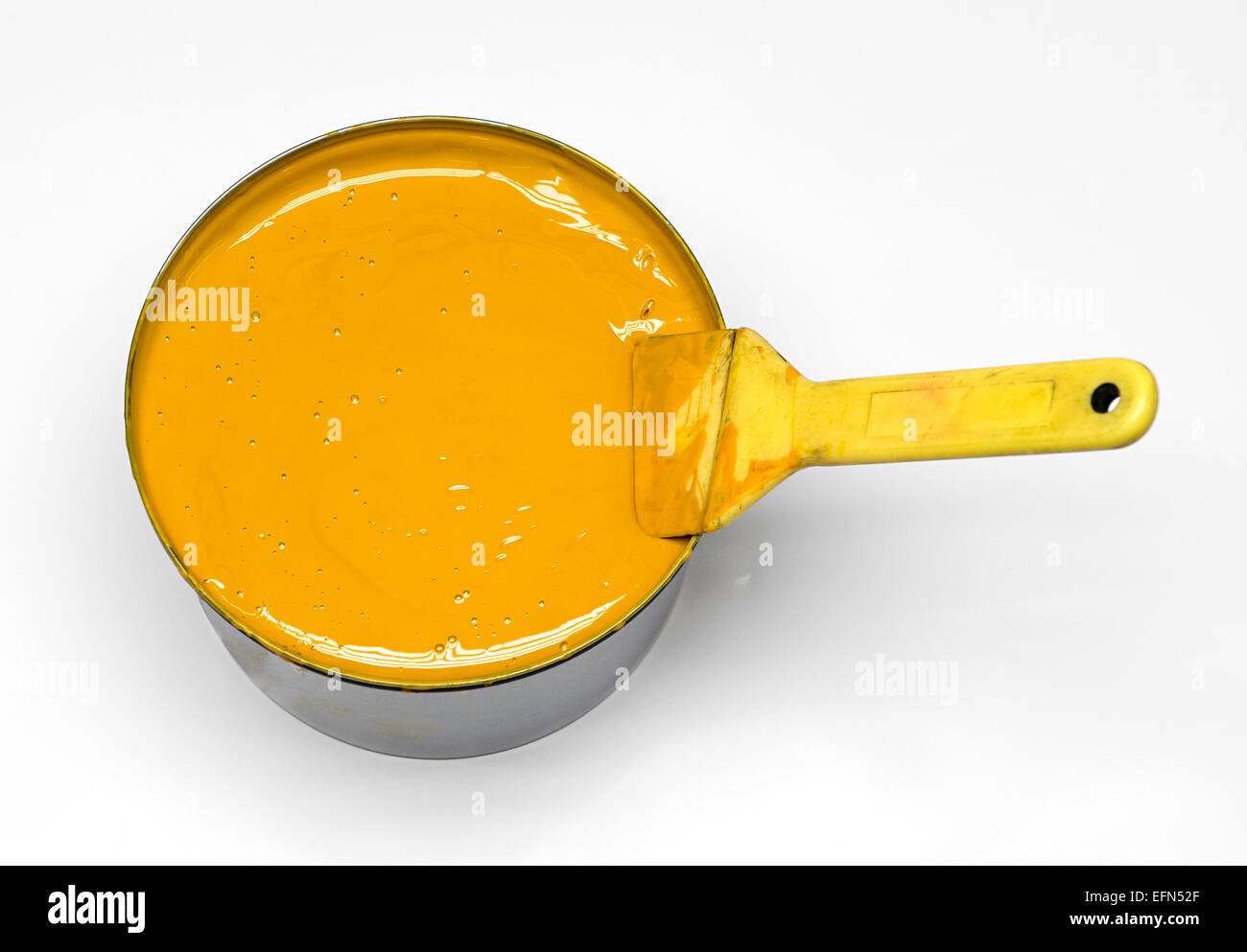 Close up Shot of Conceptual Yellow Ink in a Can with Brush Isolated on White Background. Stock Photo