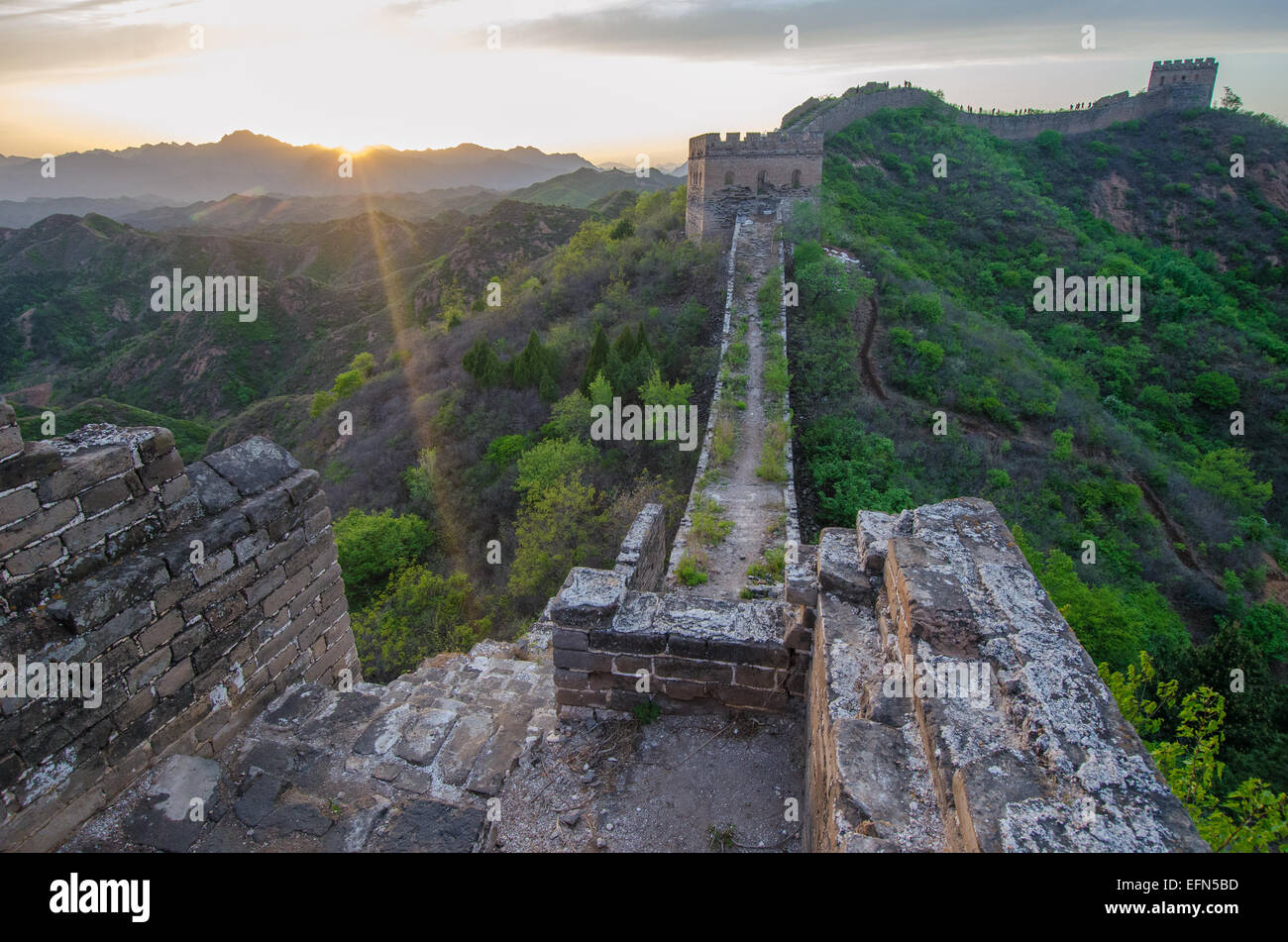 The 2,300 year old Great Wall of China is illuminated by the setting sun. Stock Photo