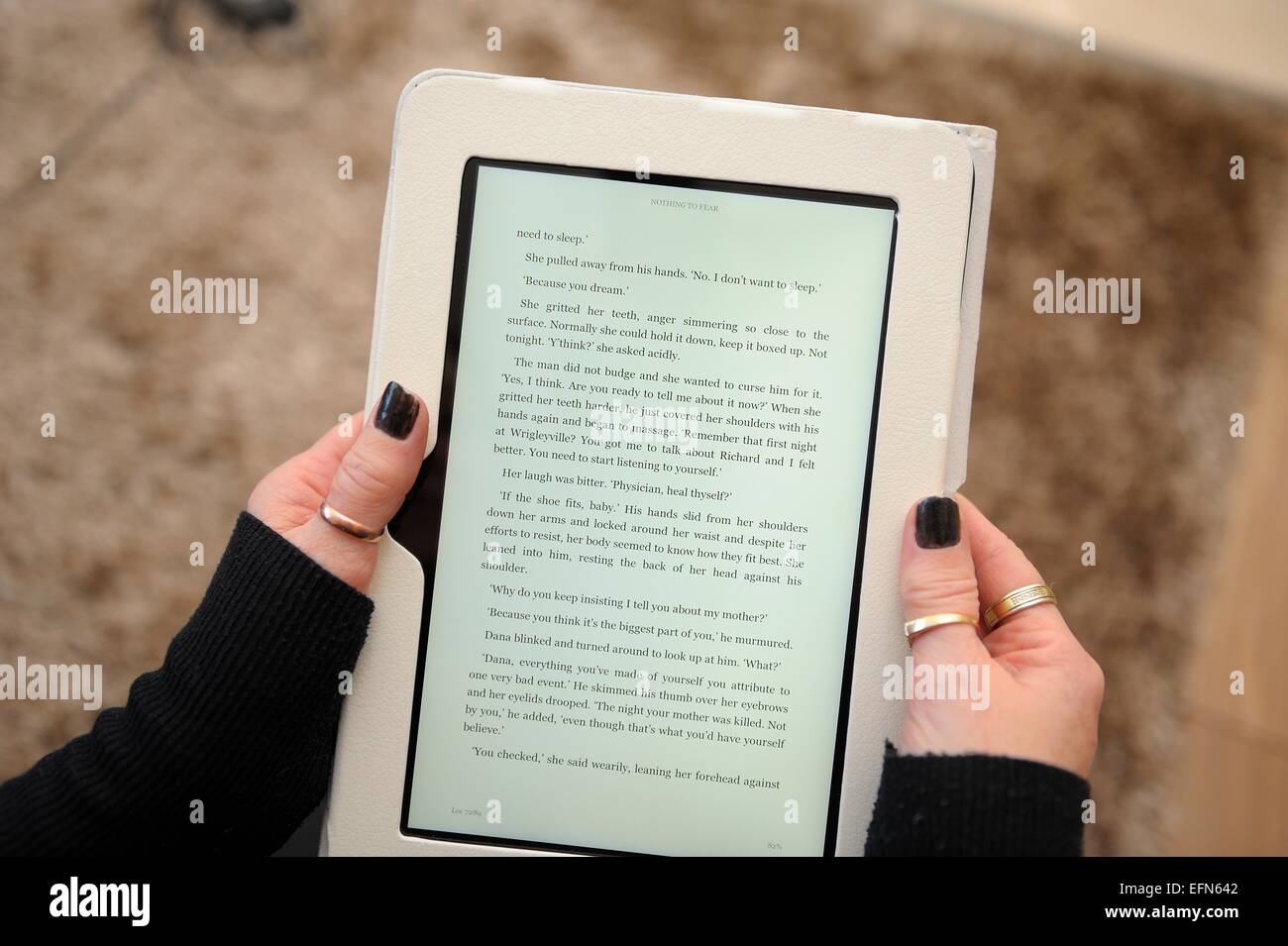 A kindle fire being used to read a book England UK Stock Photo