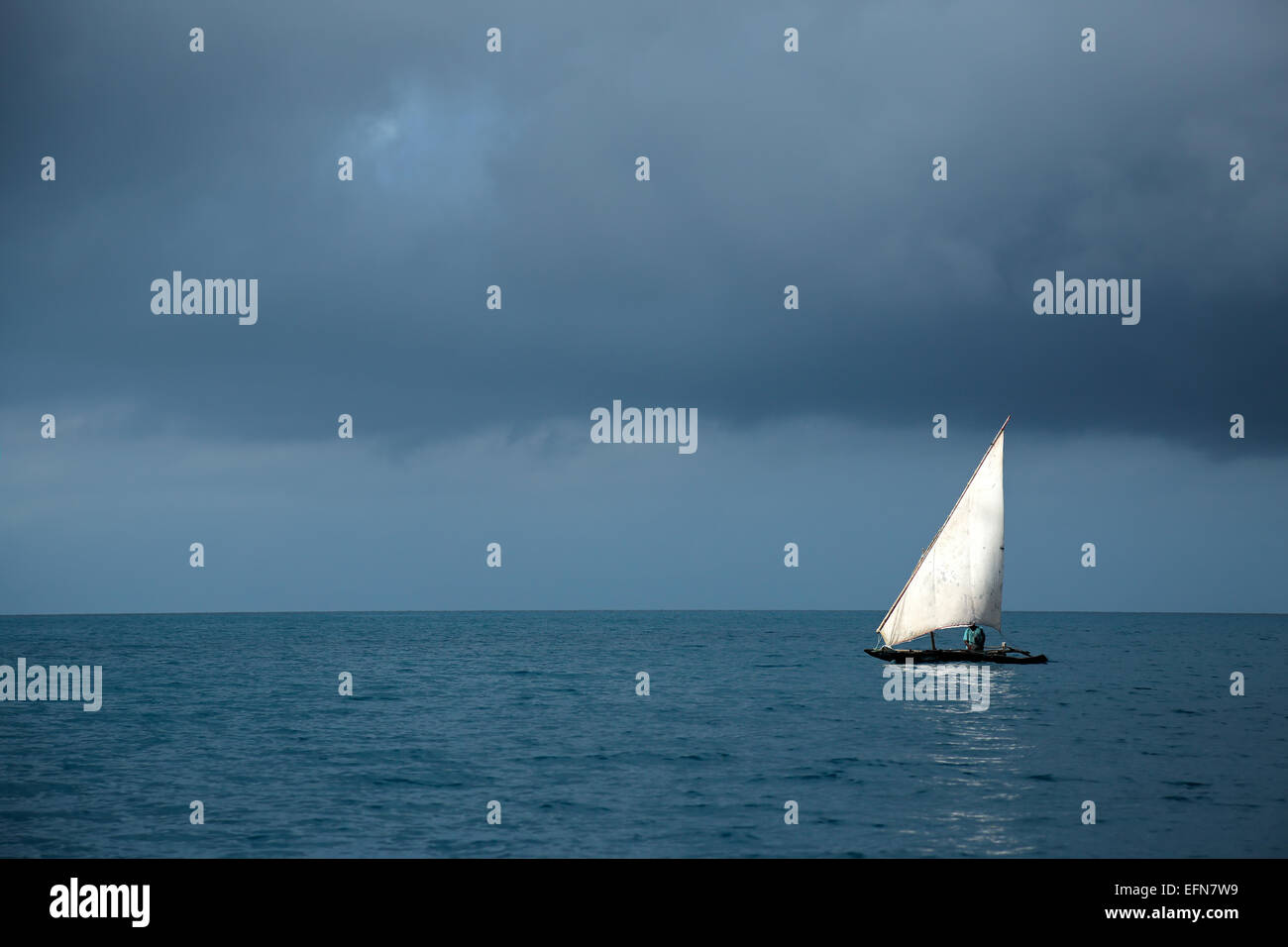 Wooden sailboat (dhow) on water with storm clouds, Zanzibar island Stock Photo