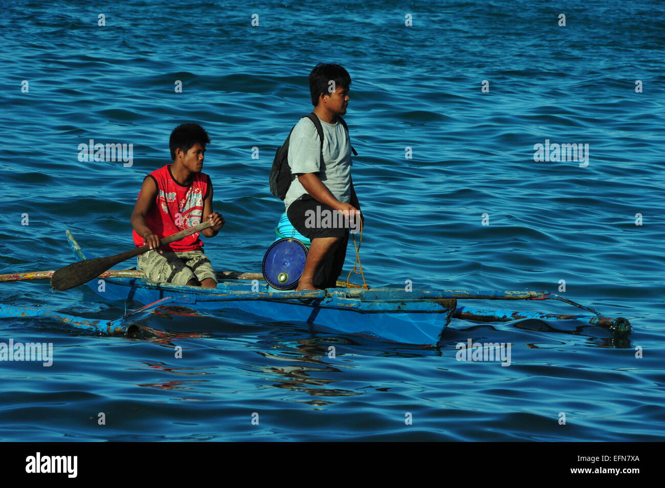 Fishermen are paddling their Banka, Sabang, Puerto Galera, Mindoro, Philippines. Stock Photo