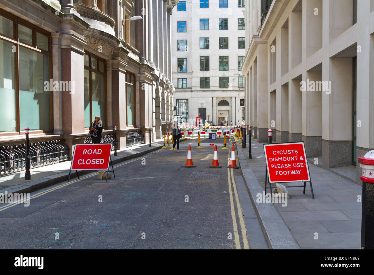 Road closed in the City of London with signs showing 'Cyclists dismount & please use footway' and 'road closed' Stock Photo