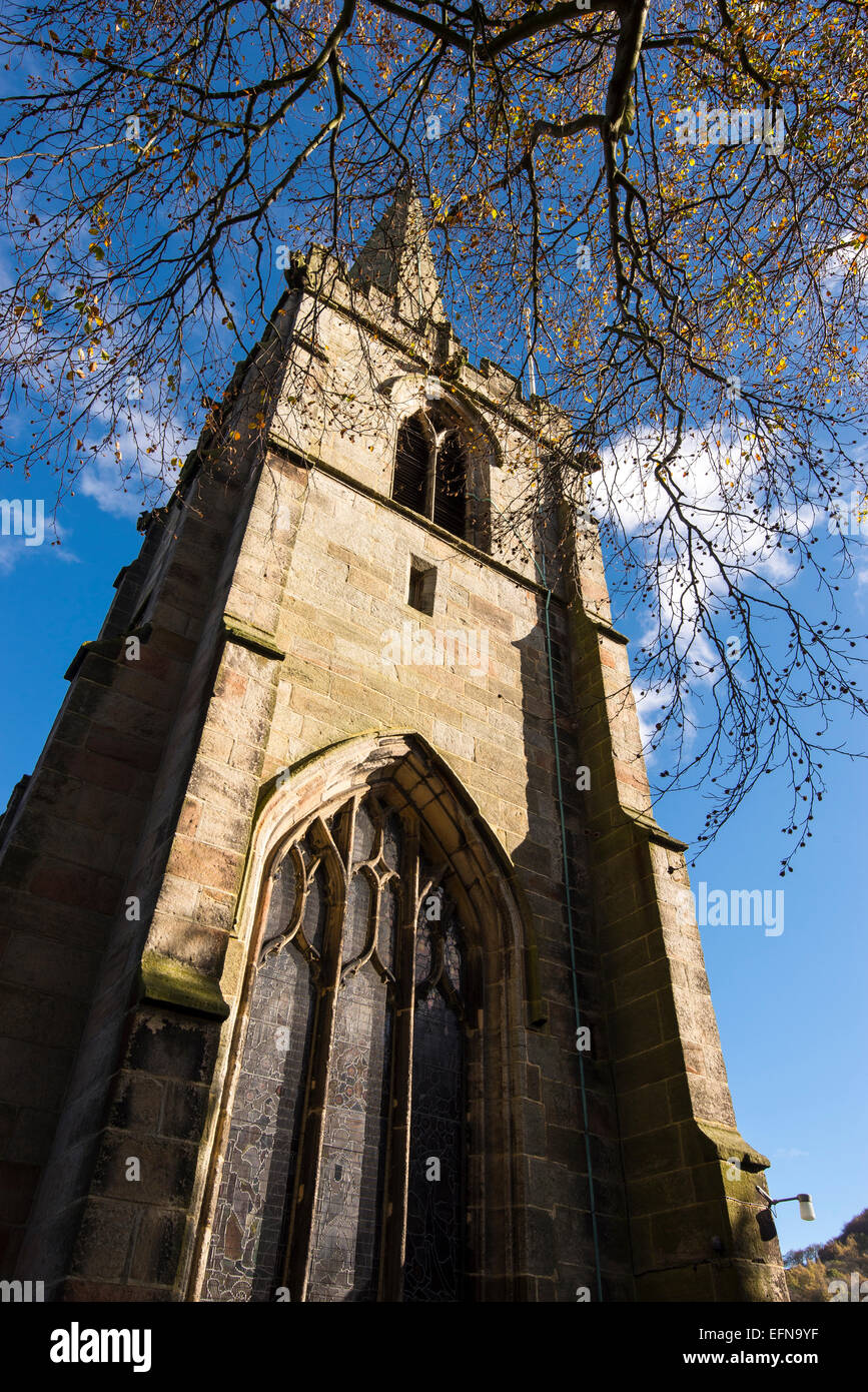 Looking up at the tower of St Michaels and All Saints church, Hathersage, Derbyshire with blue sky above. Stock Photo