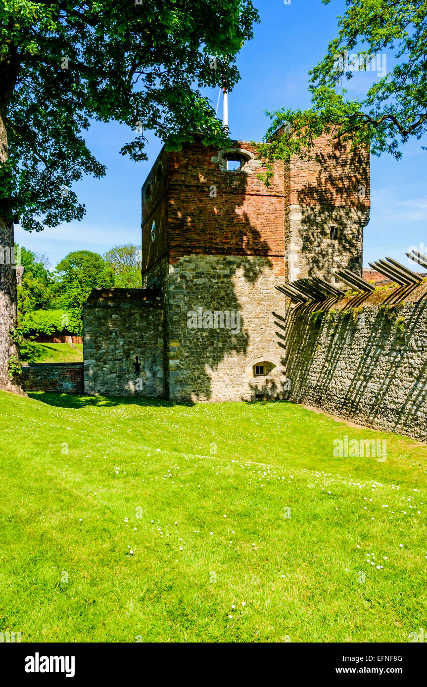 The gatehouse and adjoining walls on the landward side of Upnor Castle embedded with long sharp spikes set in tranquil grounds Stock Photo