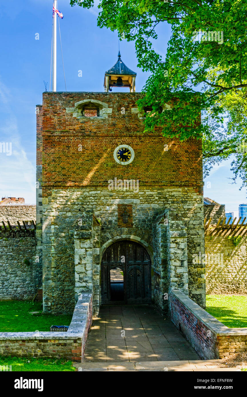 A paved path between two low walls leads to two stout wooden doors in the stone and brick built gatehouse of Upnor Castle Stock Photo
