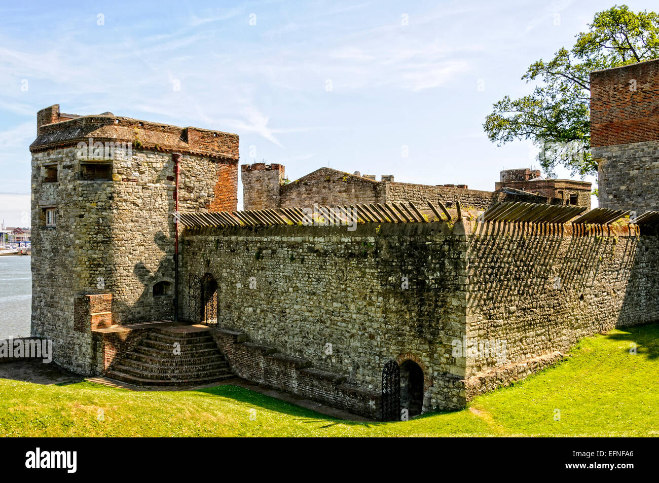 The north tower and adjoining walls embedded with sharp steel spikes of the Tudor Upnor Castle on the banks of the River Medway Stock Photo