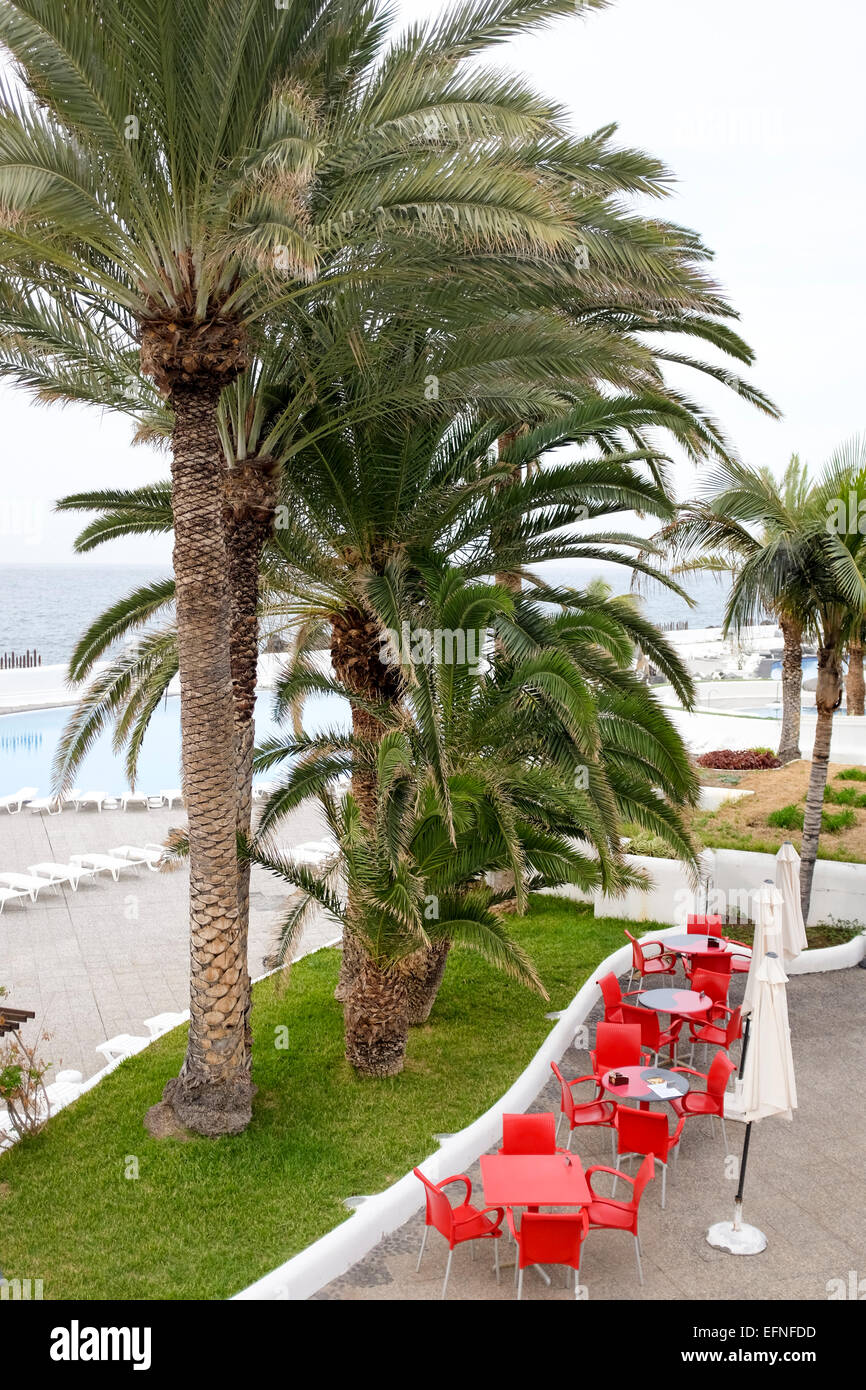 Seating and parasols set up outside cafe restaurant near Playa Jardin beach, Puerto de la Cruz, Tenerife, Spain Stock Photo