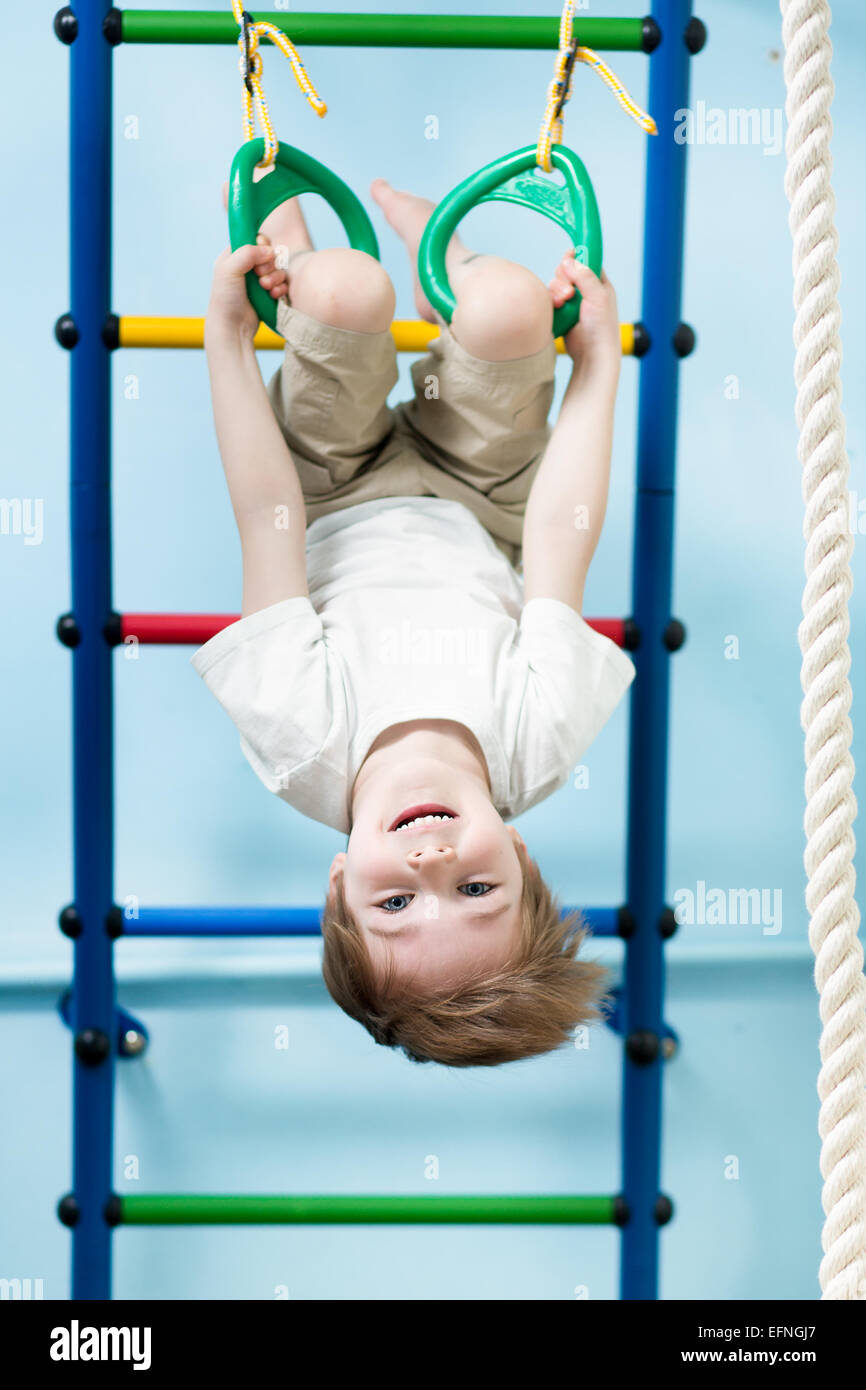 kid hanging on gymnastic rings Stock Photo