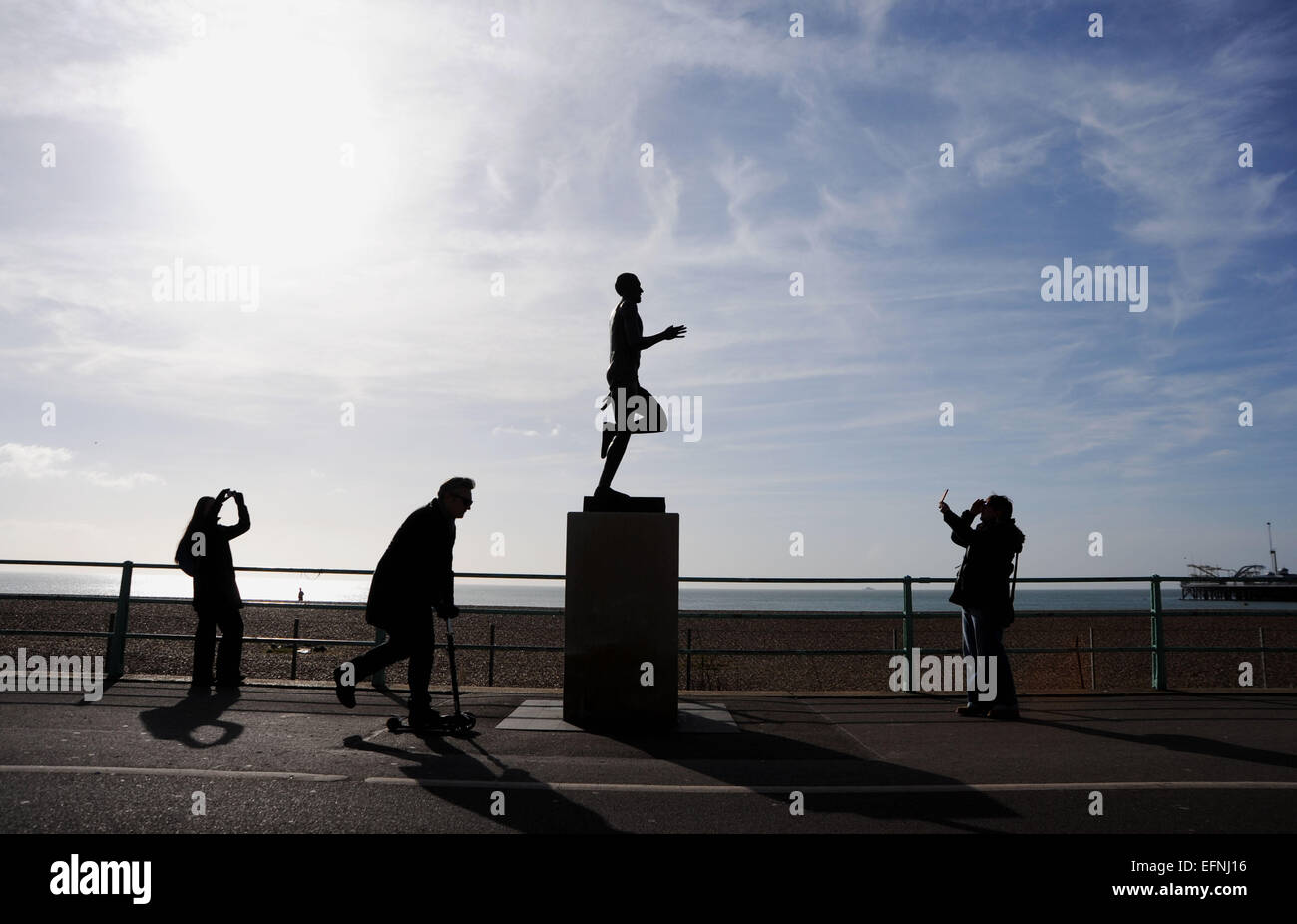 Brighton, Sussex, UK. 8th February 2015.People out enjoying the beautiful sunny winter weather today on a busy Brighton seafront by the famous Steve Ovett statue Stock Photo