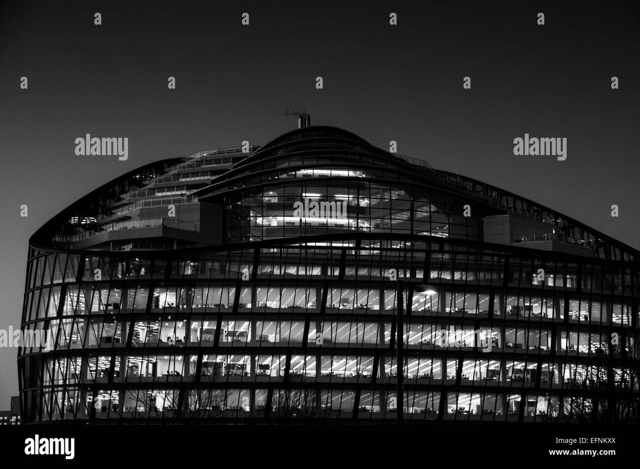 Contemporary office building at dusk with coloured lights in windows