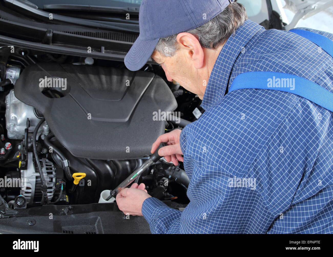 A Man checking Frost protection of  coolant in car Stock Photo