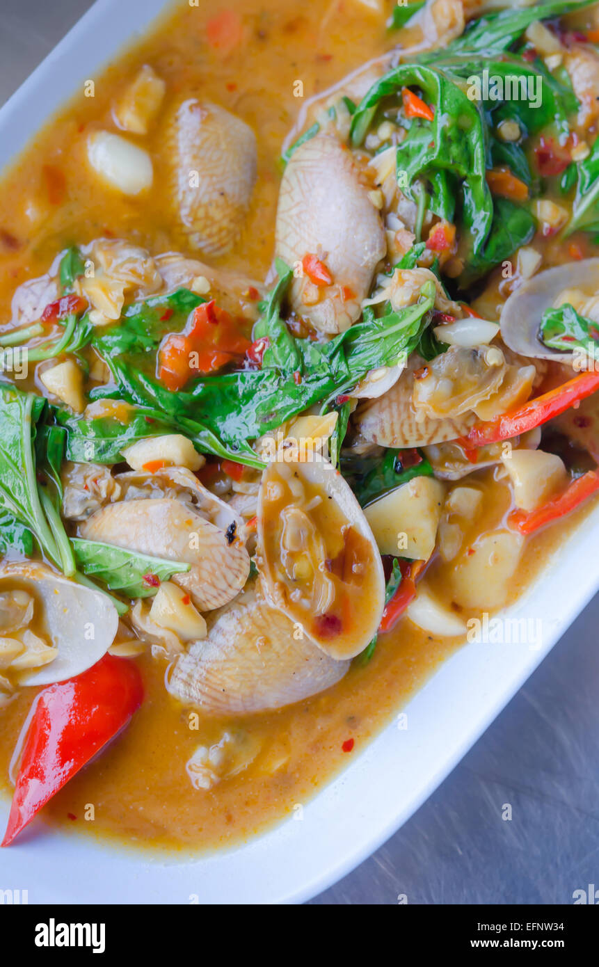 Stir fried clams with roasted chili paste and thai basil leaves Stock Photo