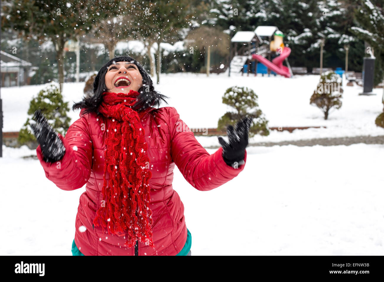 Happy Turkish woman plays with a snow outdoor in a winter day Stock Photo