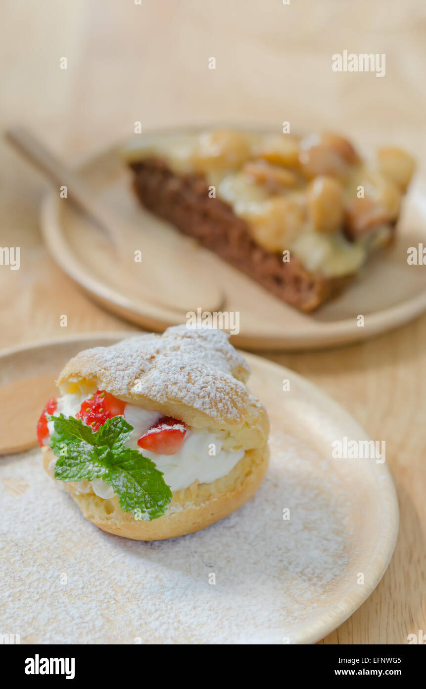 fresh strawberry Choux Cream  and macadamia cake on wooden dish Stock Photo