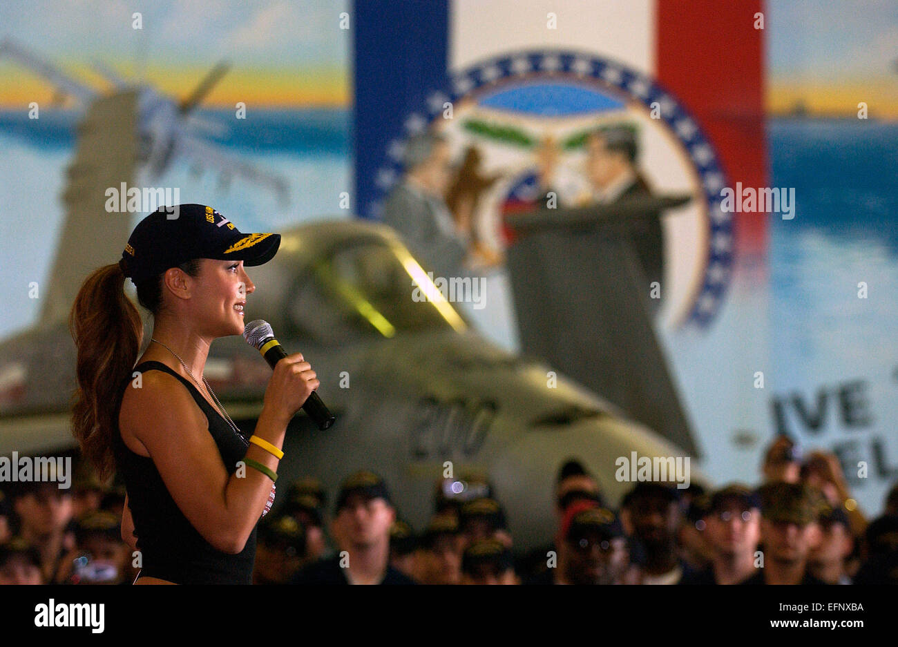 Model and sports show host Leann Tweeden cheers up the hangar bay full of sailors during the USO Christmas tour aboard the aircraft carrier USS Harry S. Truman December 15, 2004 anchored near Manama, Bahrain. Stock Photo