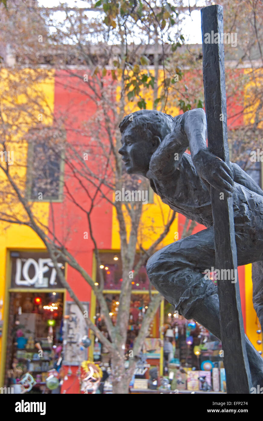 Bronze sculpture of Barefoot Boy Stilt Walker on sidewalk on Broadway Street in downtown Asheville, North Carolina. Stock Photo