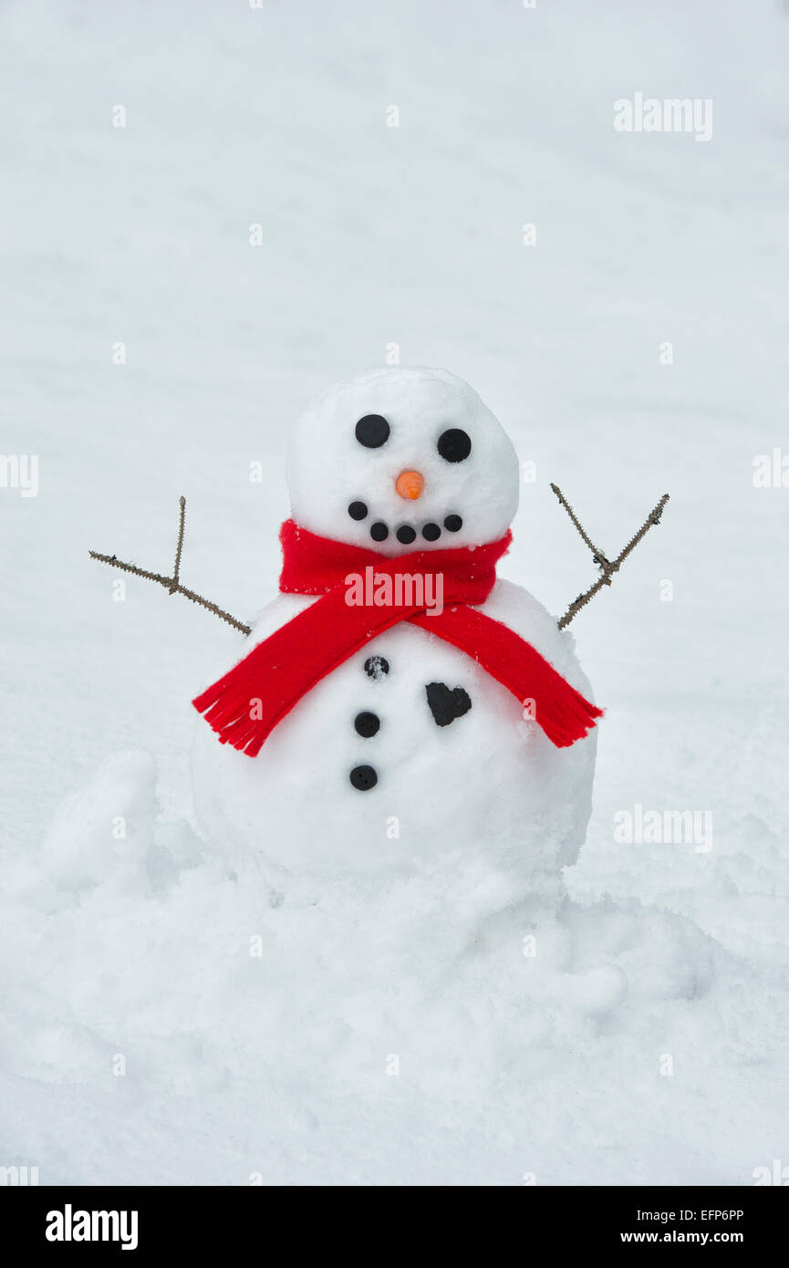 Happy snowman with a big coal heart and red scarf Stock Photo