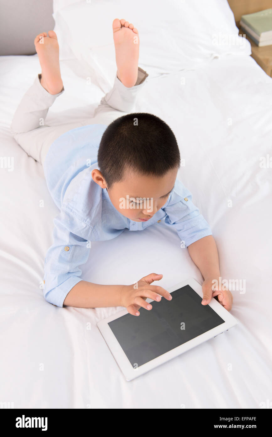Boy using tablet in bed Stock Photo Alamy