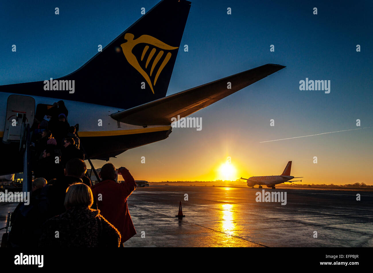 Bristol, UK.  weather. Bristol Airport, England. Passengers boarding a Ryanair flight to Dublin at sunrise as an Easyjet aircraft taxis. Stock Photo