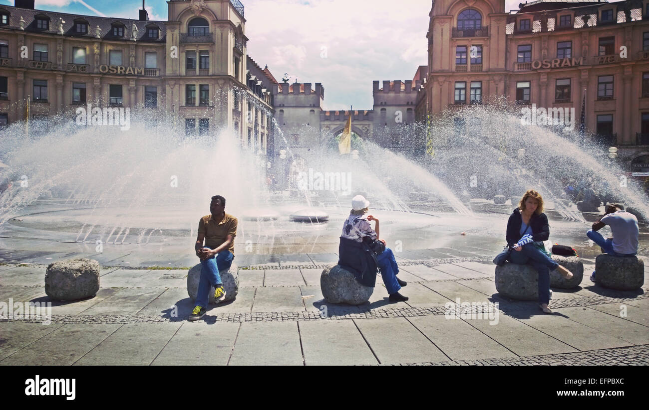 MUNICH, GERMANY hot weather in Munich, more than 30 Celsius, people look for refreshment near the fountain at Karplatz Stock Photo