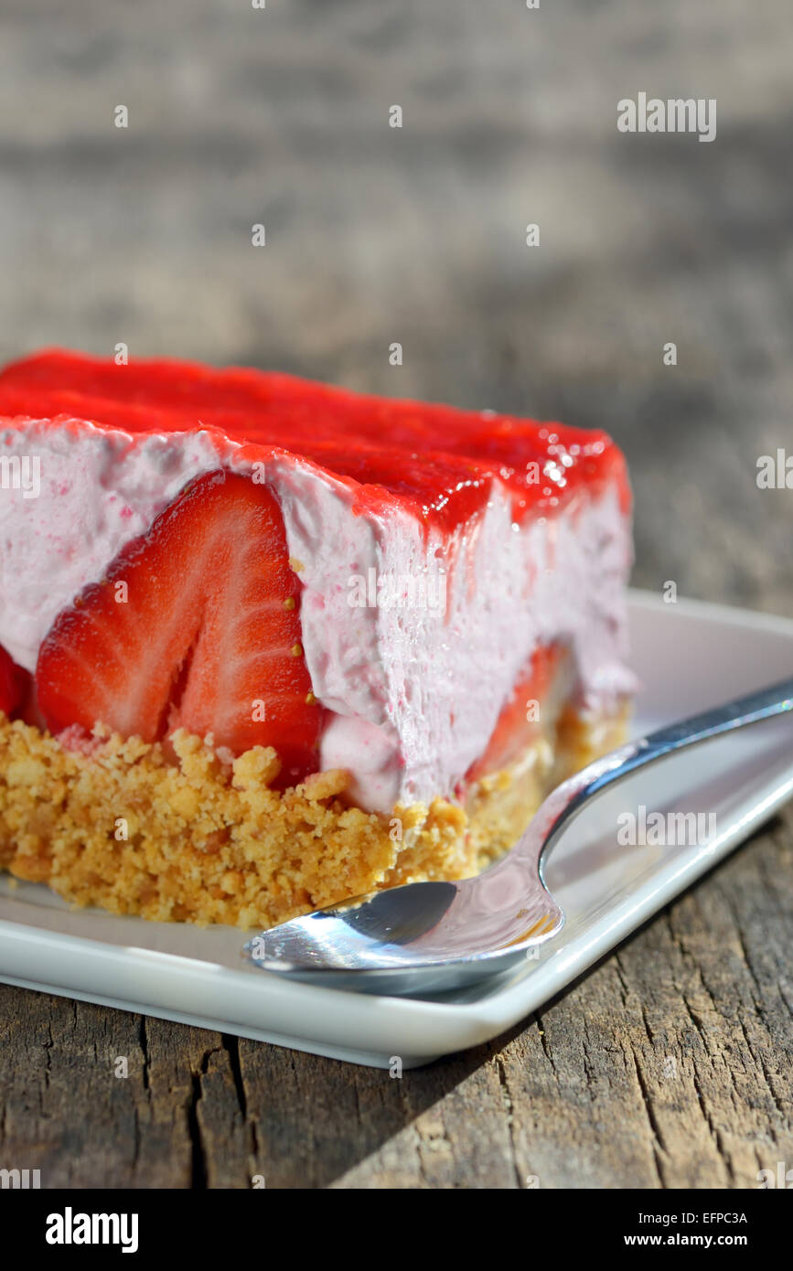 slice of strawberry cheesecake on wooden table Stock Photo