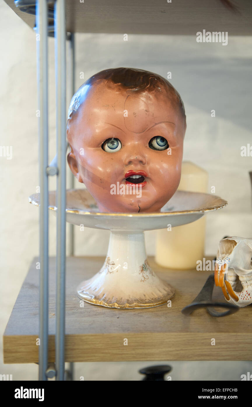 Victorian dolls head on an antique cake stand. Stock Photo