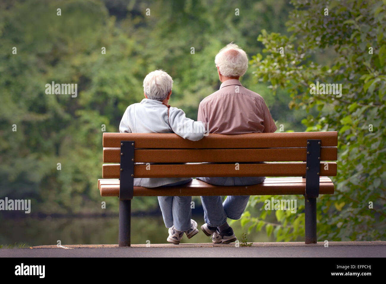 Senior couple seating on a park bench Stock Photo - Alamy