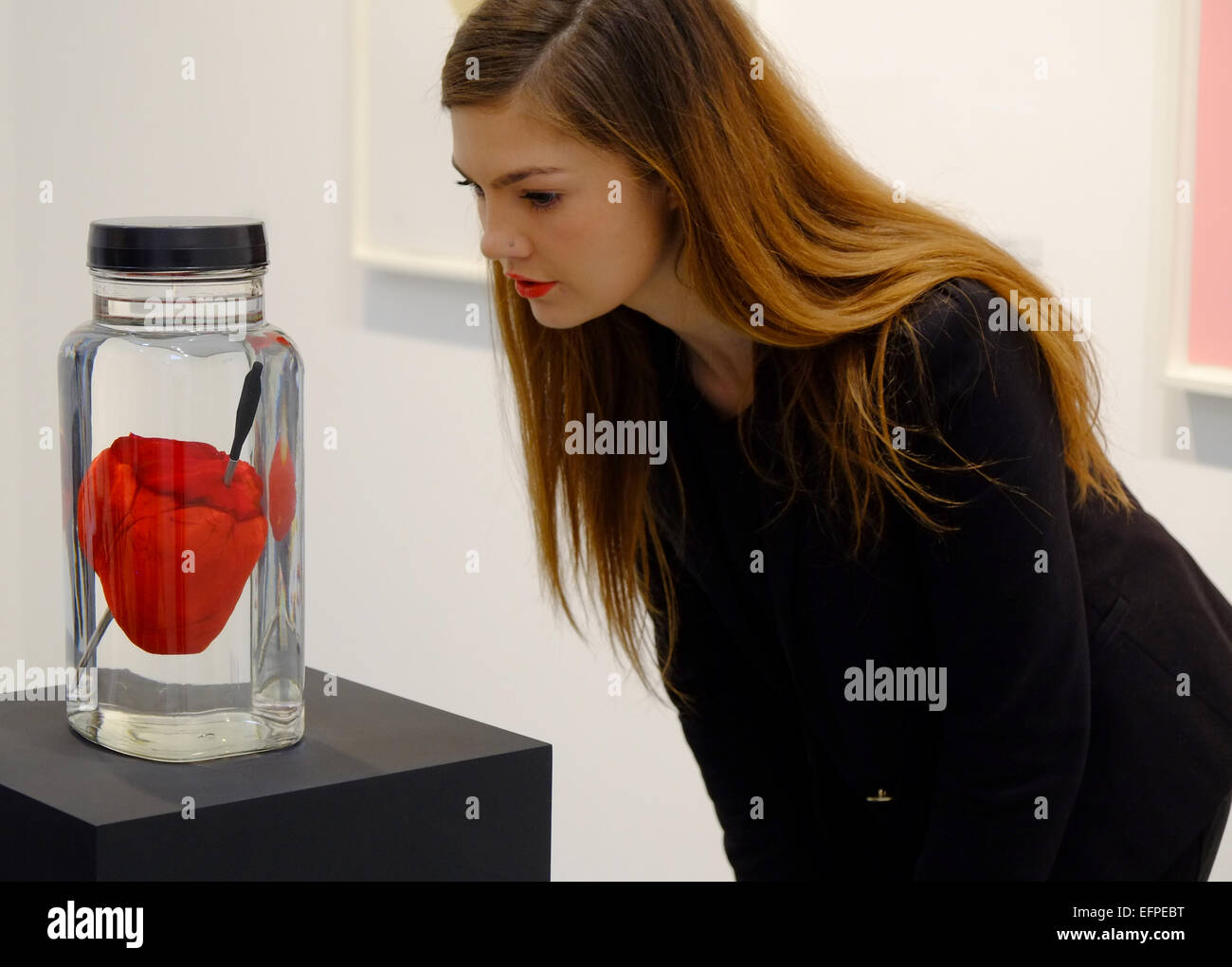 London, UK. 9th February, 2015. The exhibition for Valentines includes ‘Love Struck’, a heart pierced by a crossbow bolt suspended in a sweet jar and ‘LOVE Gold’, a portfolio of love heart prints Credit:  Rachel Megawhat/Alamy Live News Stock Photo