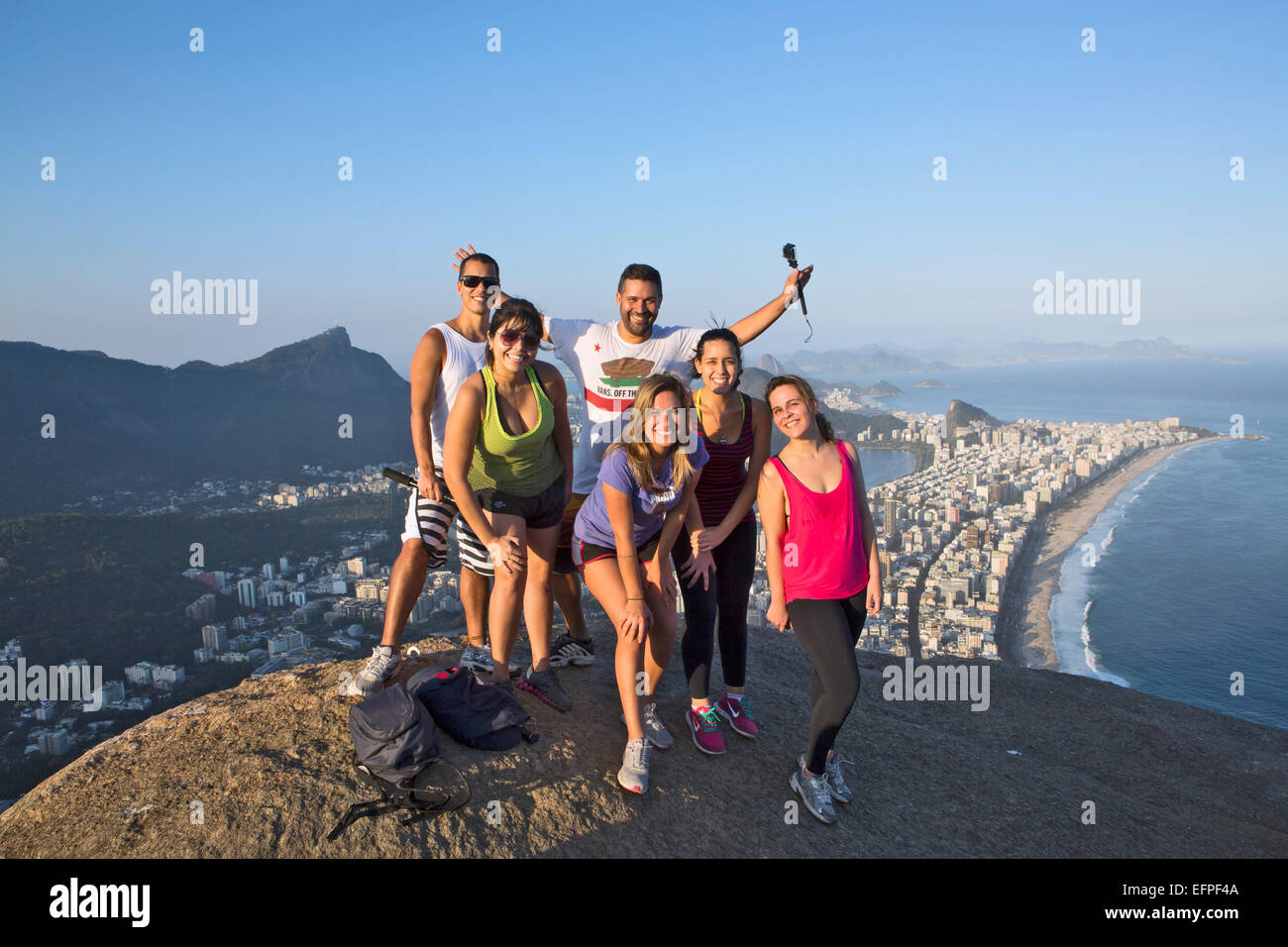 Local tourists on the summit of Dois Irmaos peak with Ipanema, Corcovado and Rio city below, Rio de Janeiro, Brazil Stock Photo
