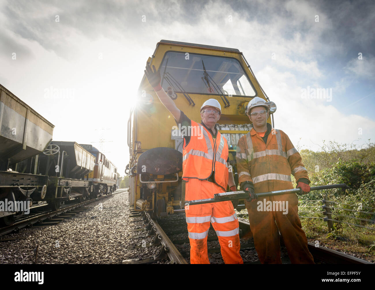Maintenance workers signalling to train on railway Stock Photo