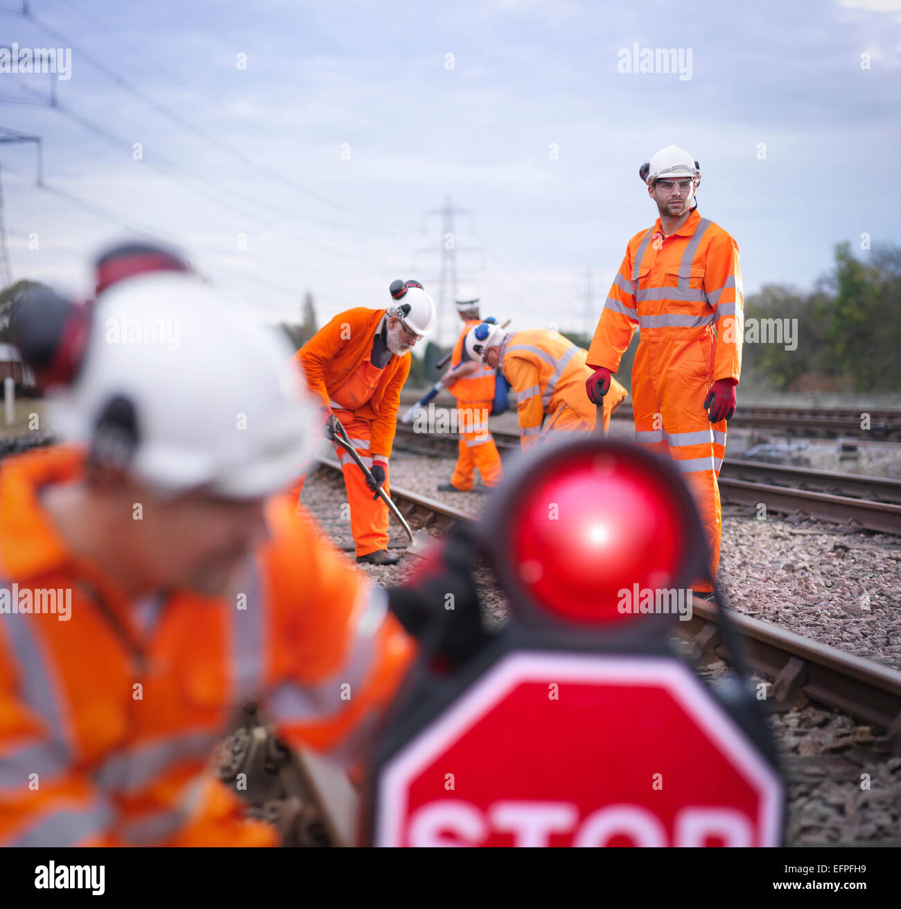 Railway maintenance workers on track with stop sign Stock Photo