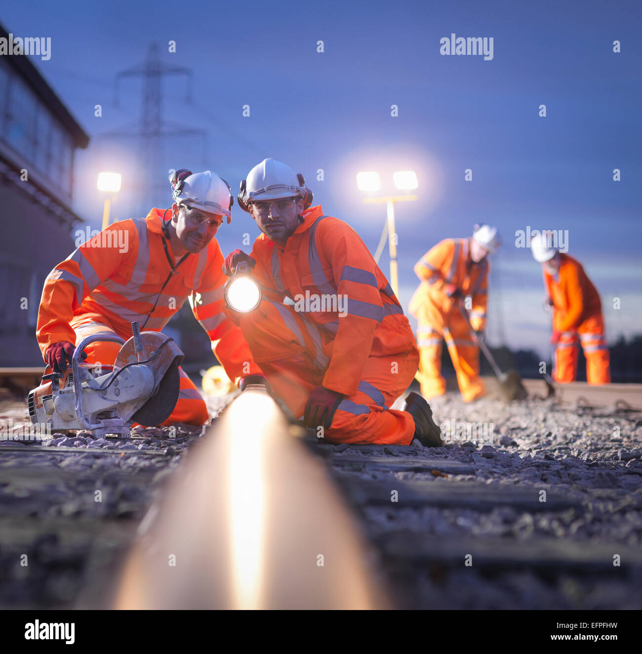 Railway maintenance workers inspecting track at night Stock Photo