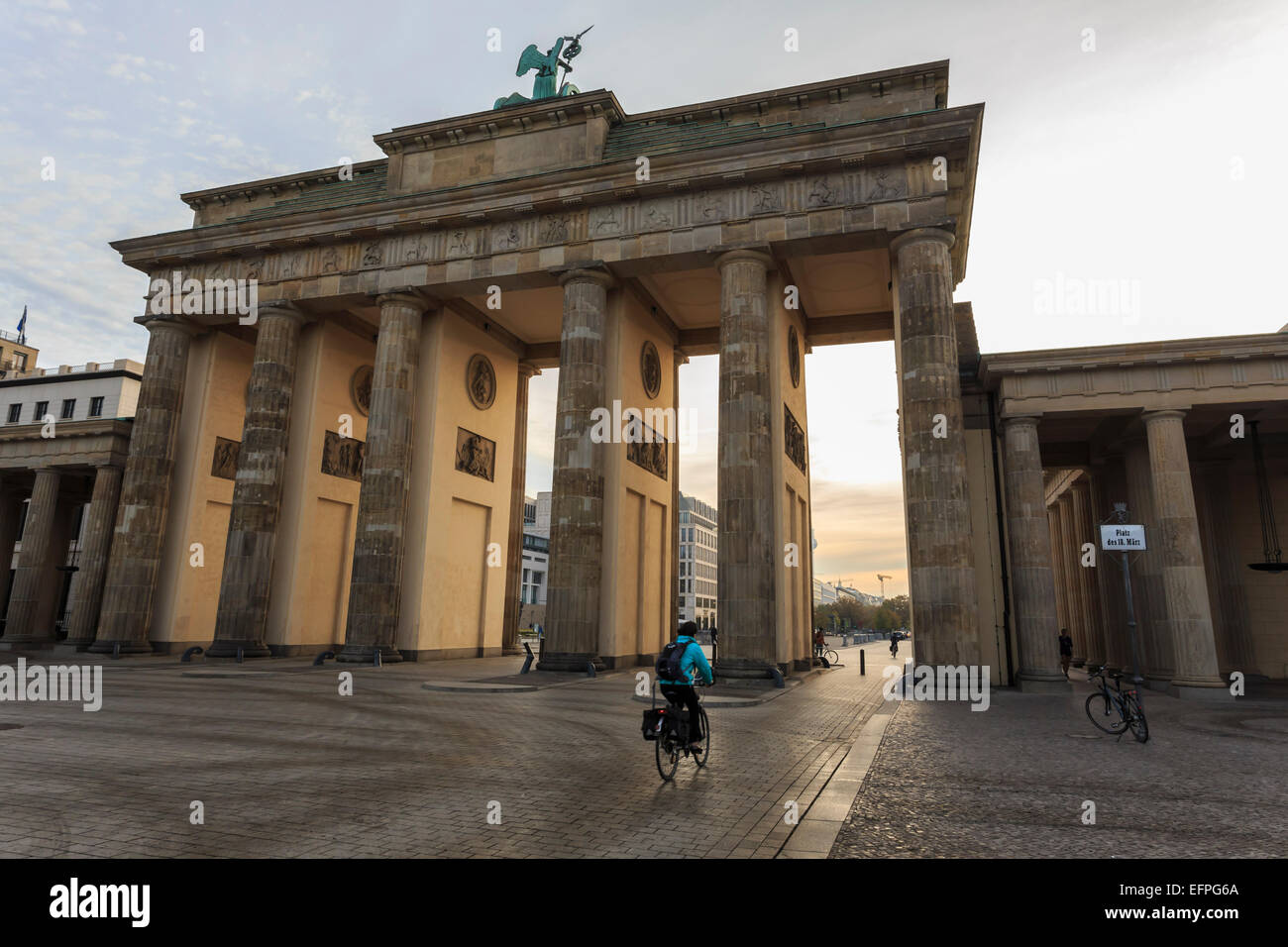 Cyclist approaches the Brandenburg Gate in the early morning, Historic Mitte, Berlin, Germany, Europe Stock Photo
