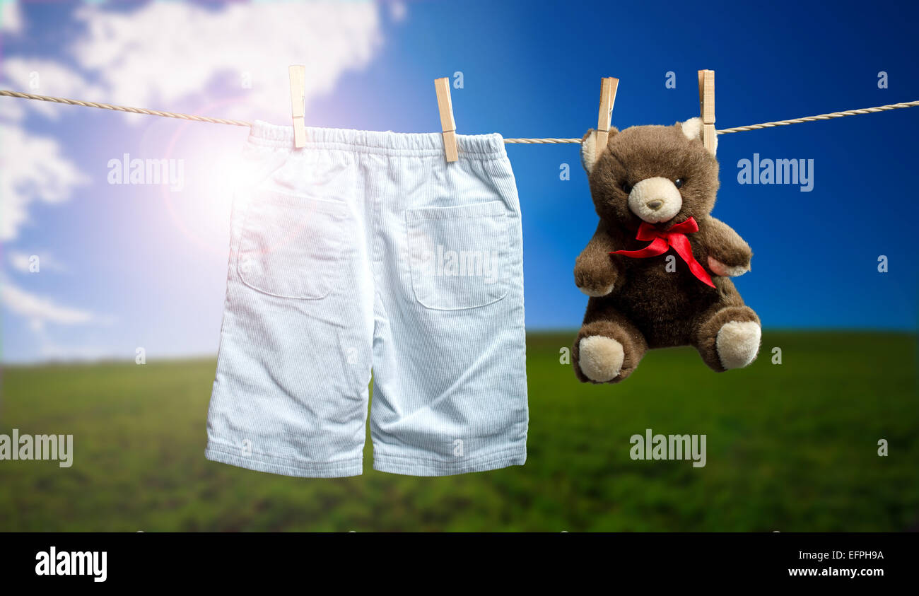 Baby boy pants, a teddy bear on the outdoor clothesline Stock Photo