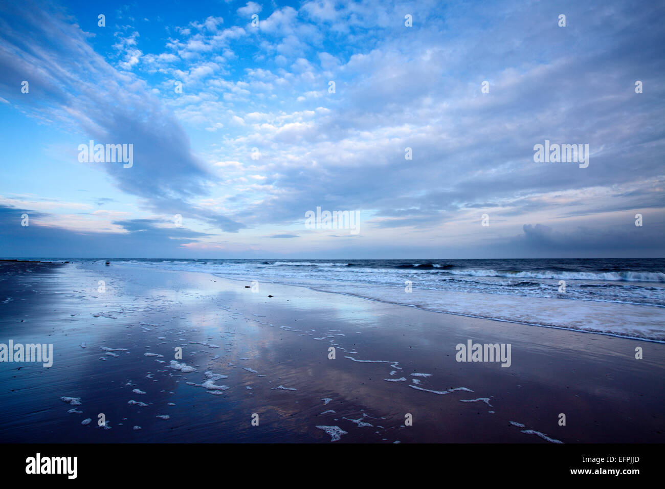 Cloud reflections at twilight on Alnmouth Beach, Northumberland, England, United Kingdom, Europe Stock Photo