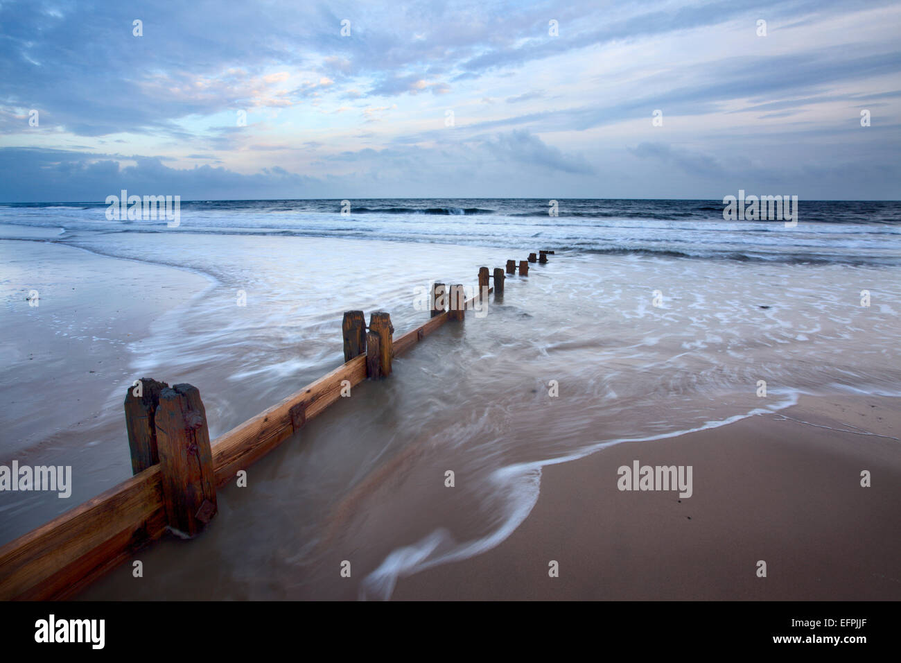 Groynes and receding tide on Alnmouth Beach at dusk, Northumberland, England, United Kingdom, Europe Stock Photo