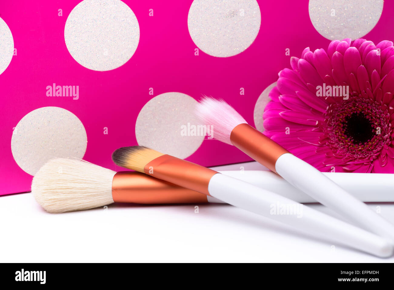 Makeup Brushes on polka dots pink background Stock Photo